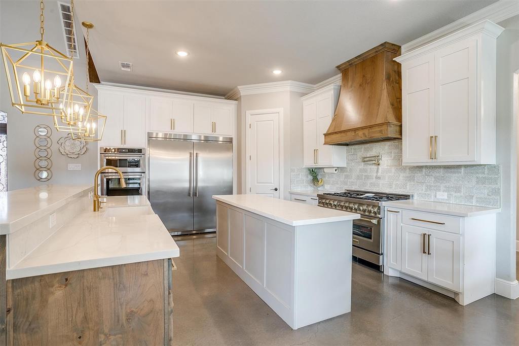 3207 Hummingbird Court Granbury, TX 76049 - Photo 9 of 40 a kitchen with stainless steel appliances a stove a sink and a refrigerator