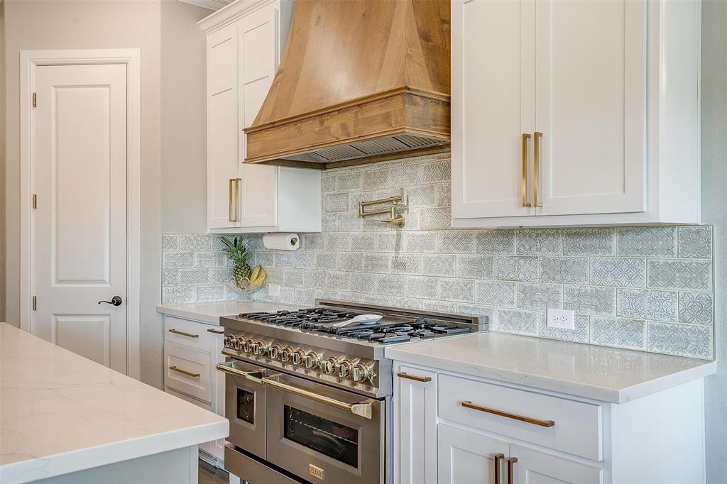 3207 Hummingbird Court Granbury, TX 76049 - Photo 10 of 40 a kitchen with a stove and white cabinets