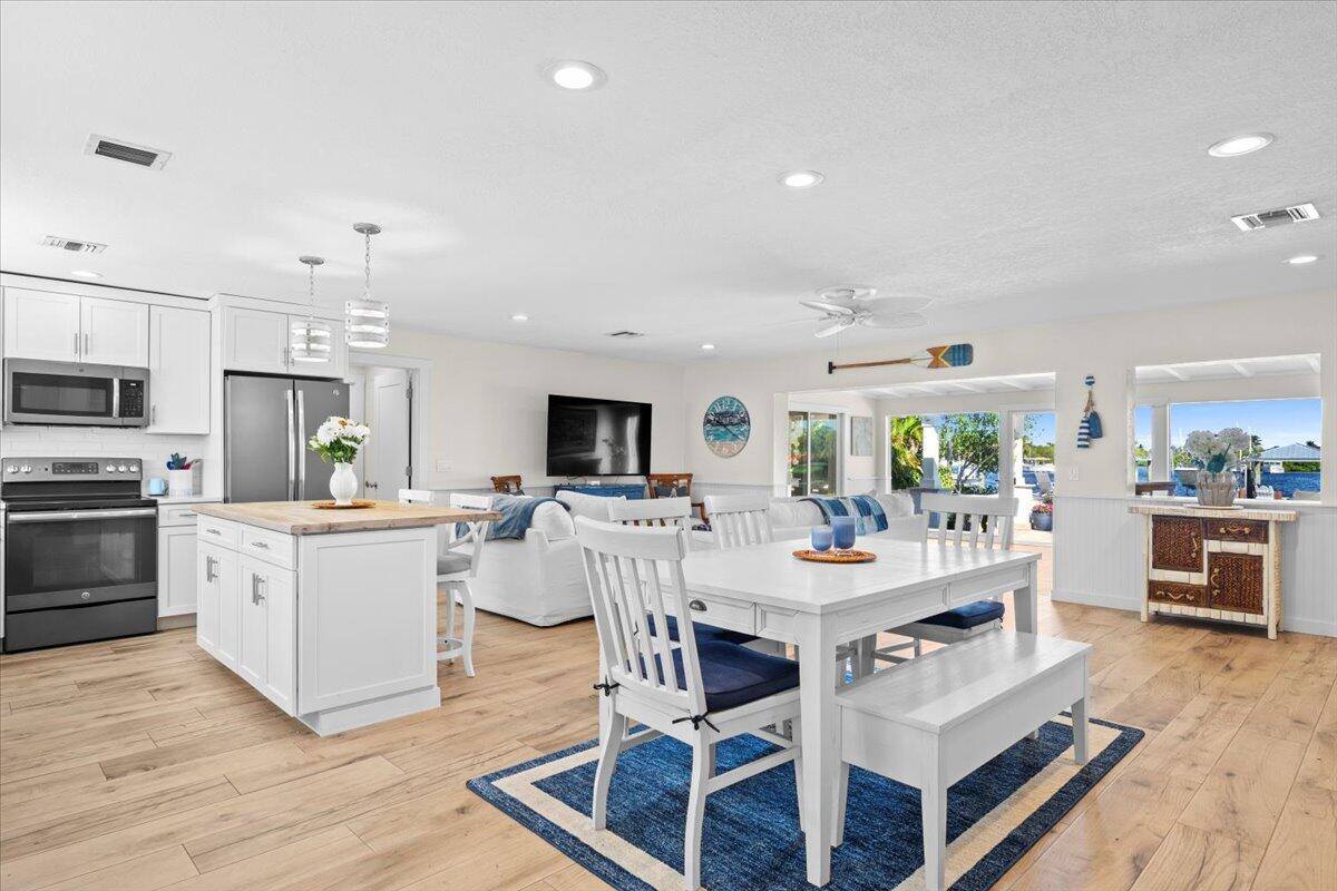 119 Elsa Road Jupiter, FL 33477 - Photo 44 of 44 a view of a dining area with furniture wooden floor and chandelier