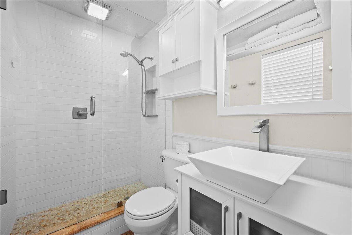 119 Elsa Road Jupiter, FL 33477 - Photo 28 of 44 a bathroom with a sink a toilet and a mirror