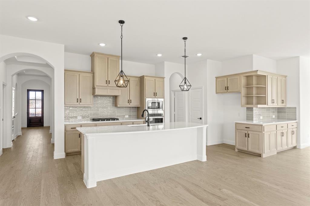 610 Tenor Drive Forney, TX 75126 - Photo 2 of 30 a large kitchen with stainless steel appliances kitchen island granite countertop a stove a sink a refrigerator and white cabinets with wooden floor
