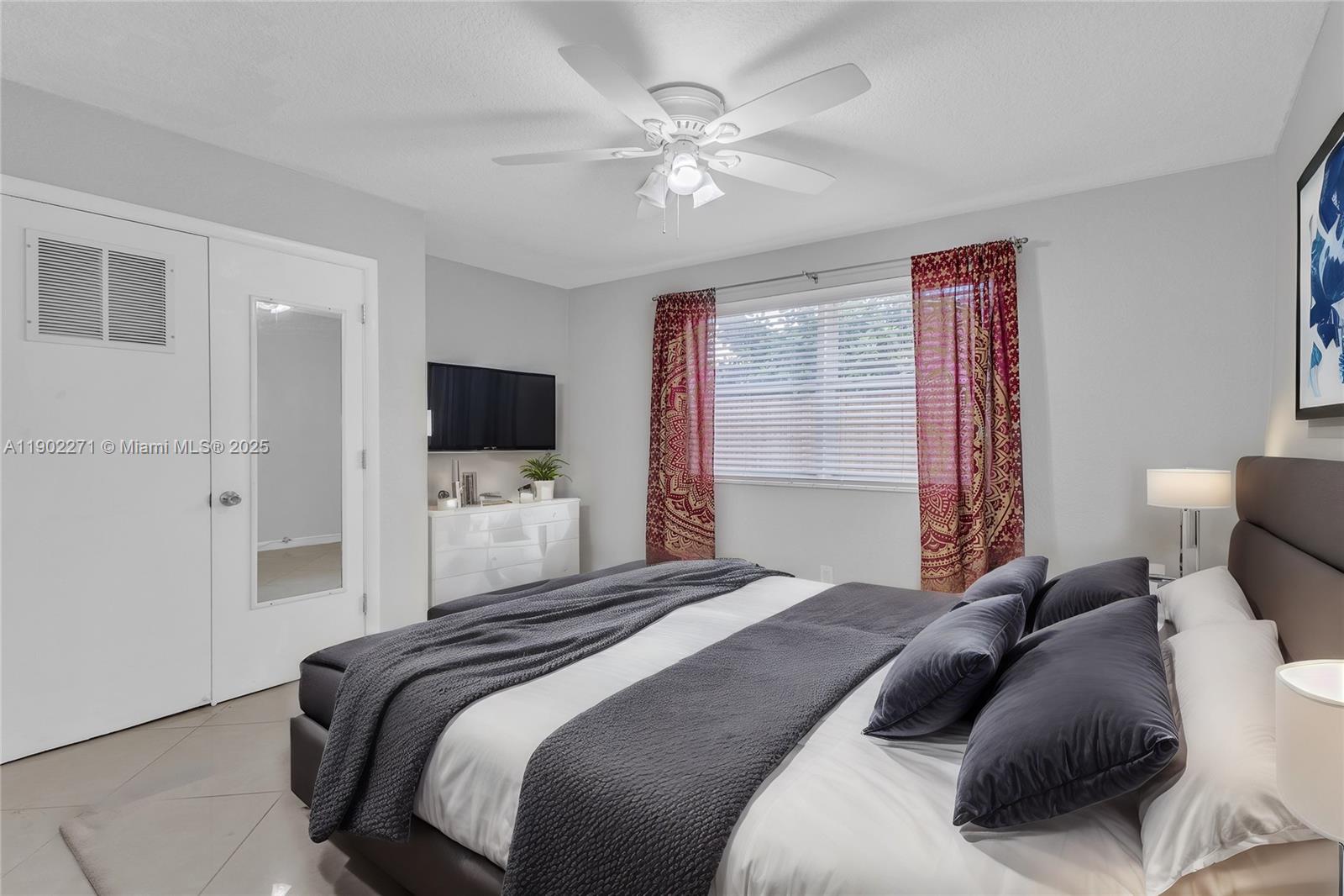 2175 Northeast 56th Street, Unit 105 Fort Lauderdale, FL 33308 - Photo 25 of 26 a bedroom with a large bed and a flat screen tv