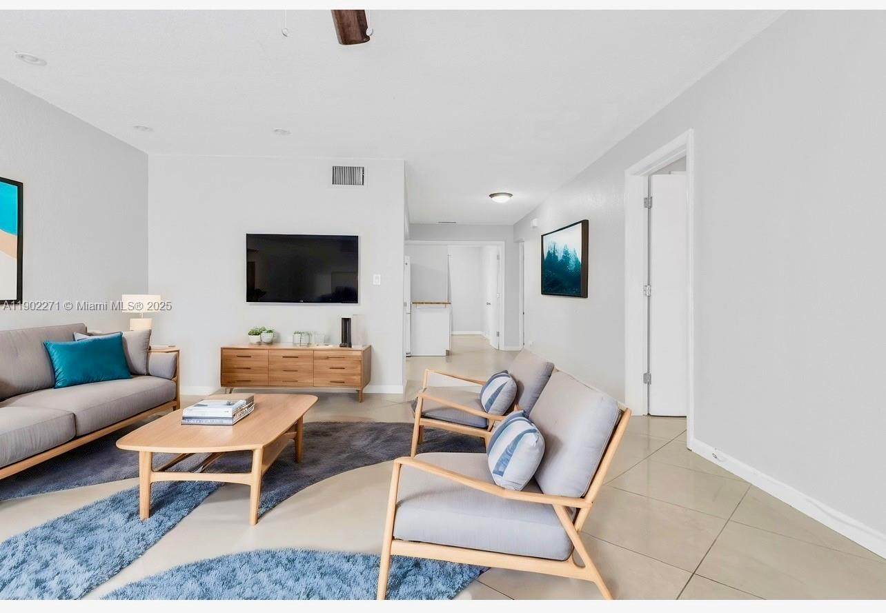 2175 Northeast 56th Street, Unit 105 Fort Lauderdale, FL 33308 - Photo 4 of 26 a living room with furniture and a flat screen tv
