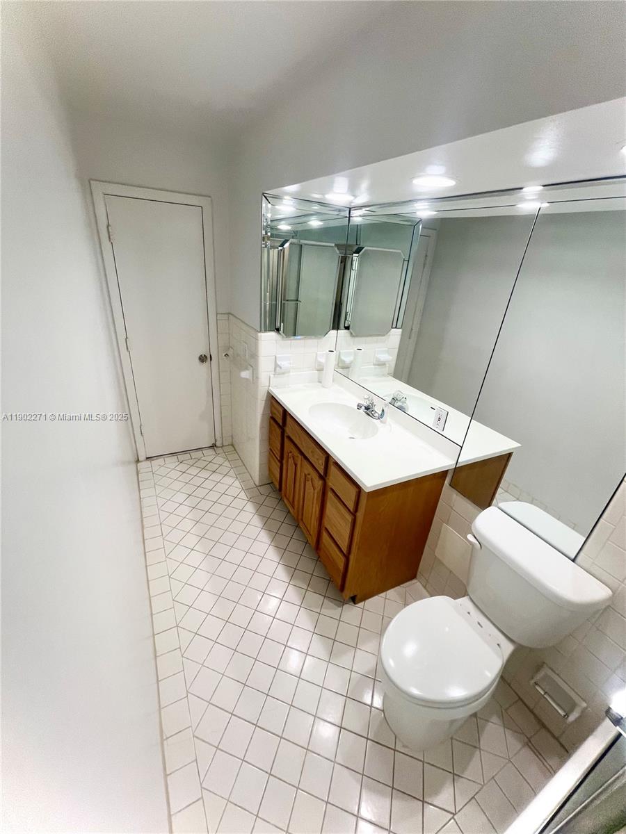 2175 Northeast 56th Street, Unit 105 Fort Lauderdale, FL 33308 - Photo 6 of 26 a bathroom with a sink mirror vanity and toilet