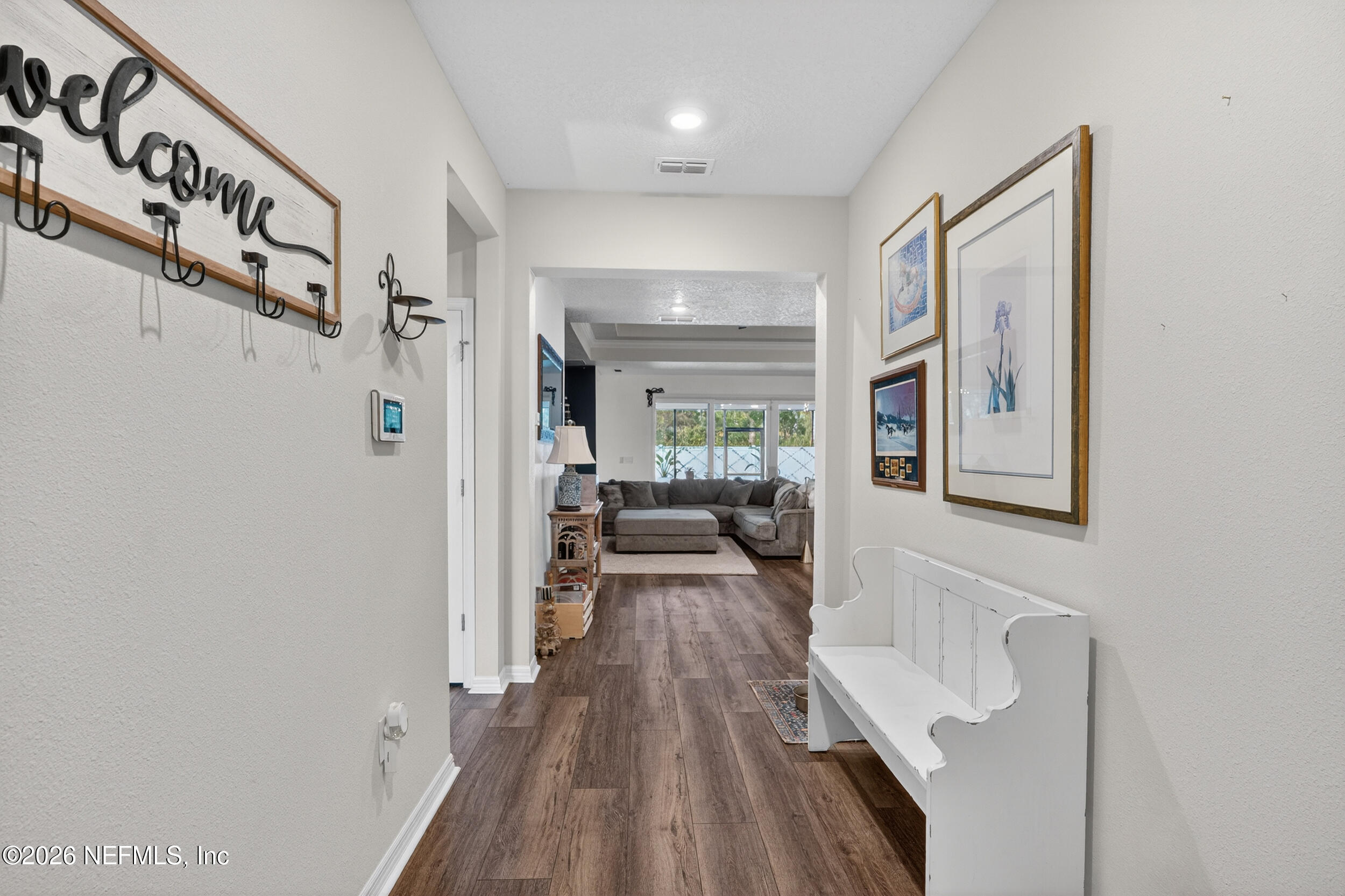4558 Farmhouse Gate Trail Jacksonville, FL 32226 - Photo 3 of 34 a hallway with wooden floor and windows