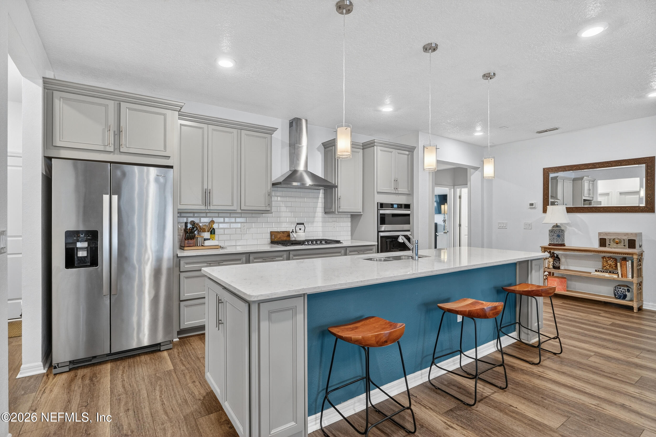 4558 Farmhouse Gate Trail Jacksonville, FL 32226 - Photo 6 of 34 a kitchen with stainless steel appliances granite countertop a refrigerator a sink dishwasher a stove and white countertops with wooden floor