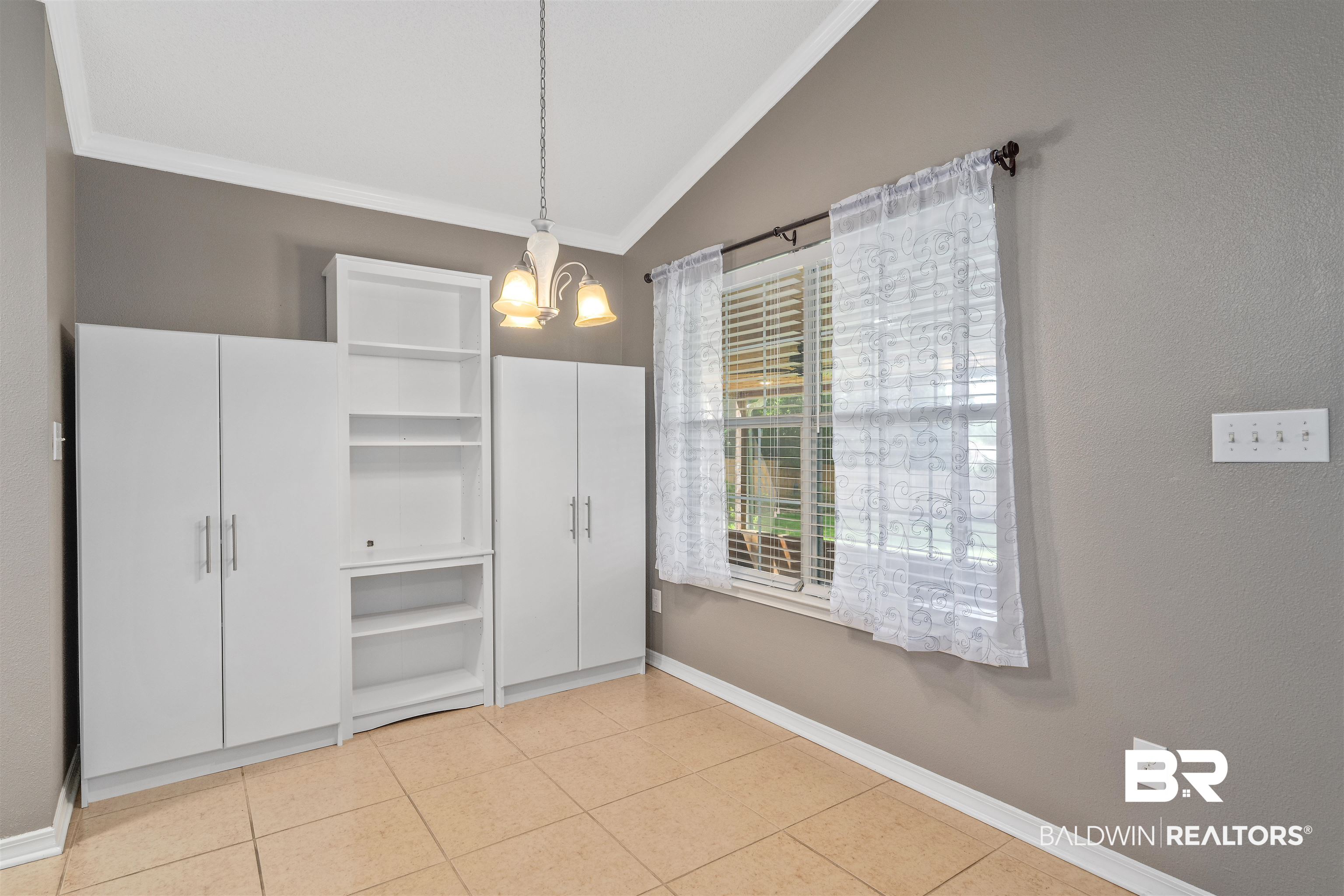 11097 Pontchartrain Loop Daphne, AL 36526 - Photo 12 of 28 Unfurnished dining area featuring ornamental molding, lofted ceiling, a chandelier, and light tile patterned floors