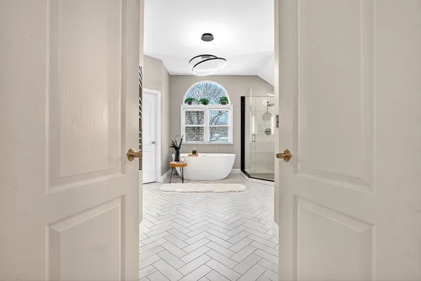 a spacious bathroom with a tub sink and mirror