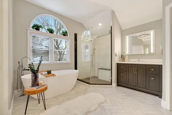 a spacious bathroom with a double vanity sink a mirror and a bathtub