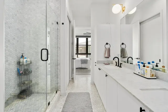 a bathroom with a double vanity sink mirror and shower