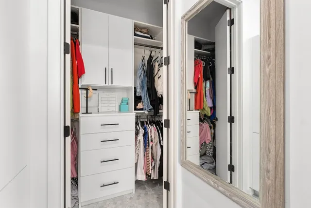 a view of walk in closet with clothes