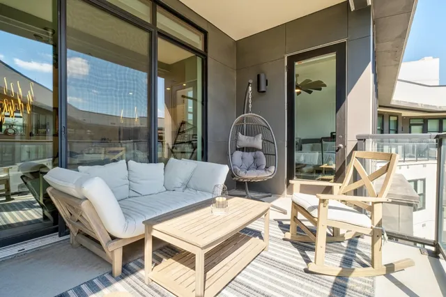 a living room with furniture a table and a large window
