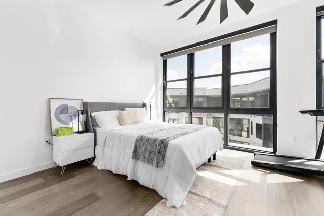 a bedroom with a bed and a large window