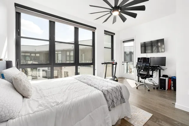 a bedroom with a bed and a large window