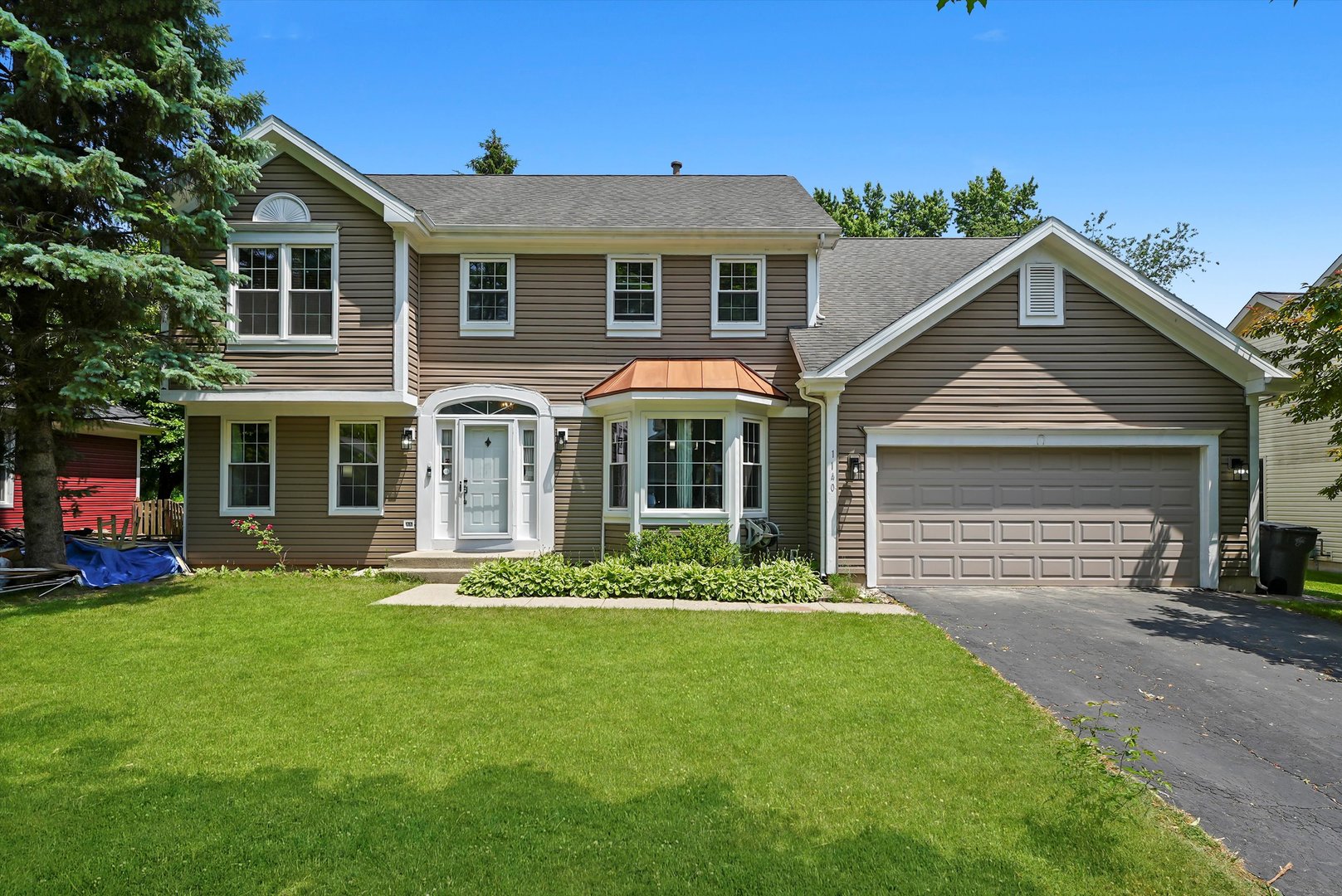 a front view of a house with a garden and yard