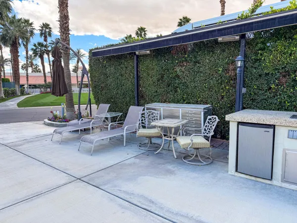 a view of a patio with a table and chairs under an umbrella