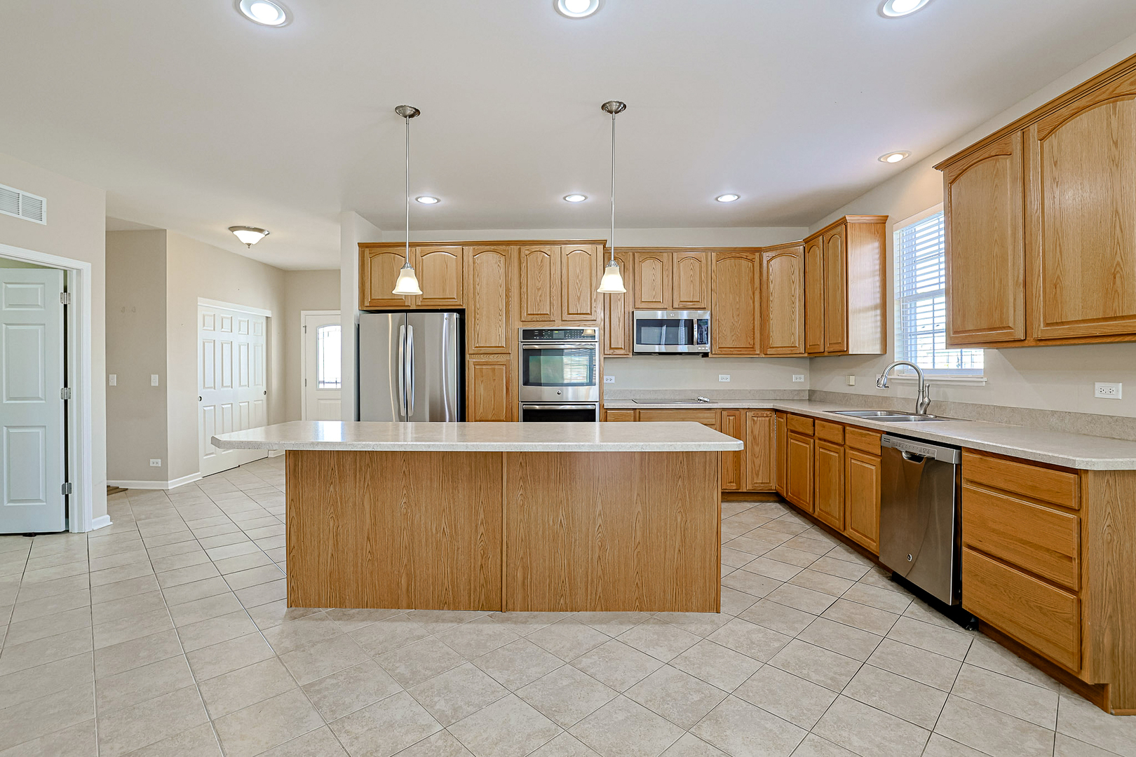 8800 Templeton Road Huntley, IL 60142 - Photo 7 of 31 a large kitchen with kitchen island a large counter top stainless steel appliances and cabinets