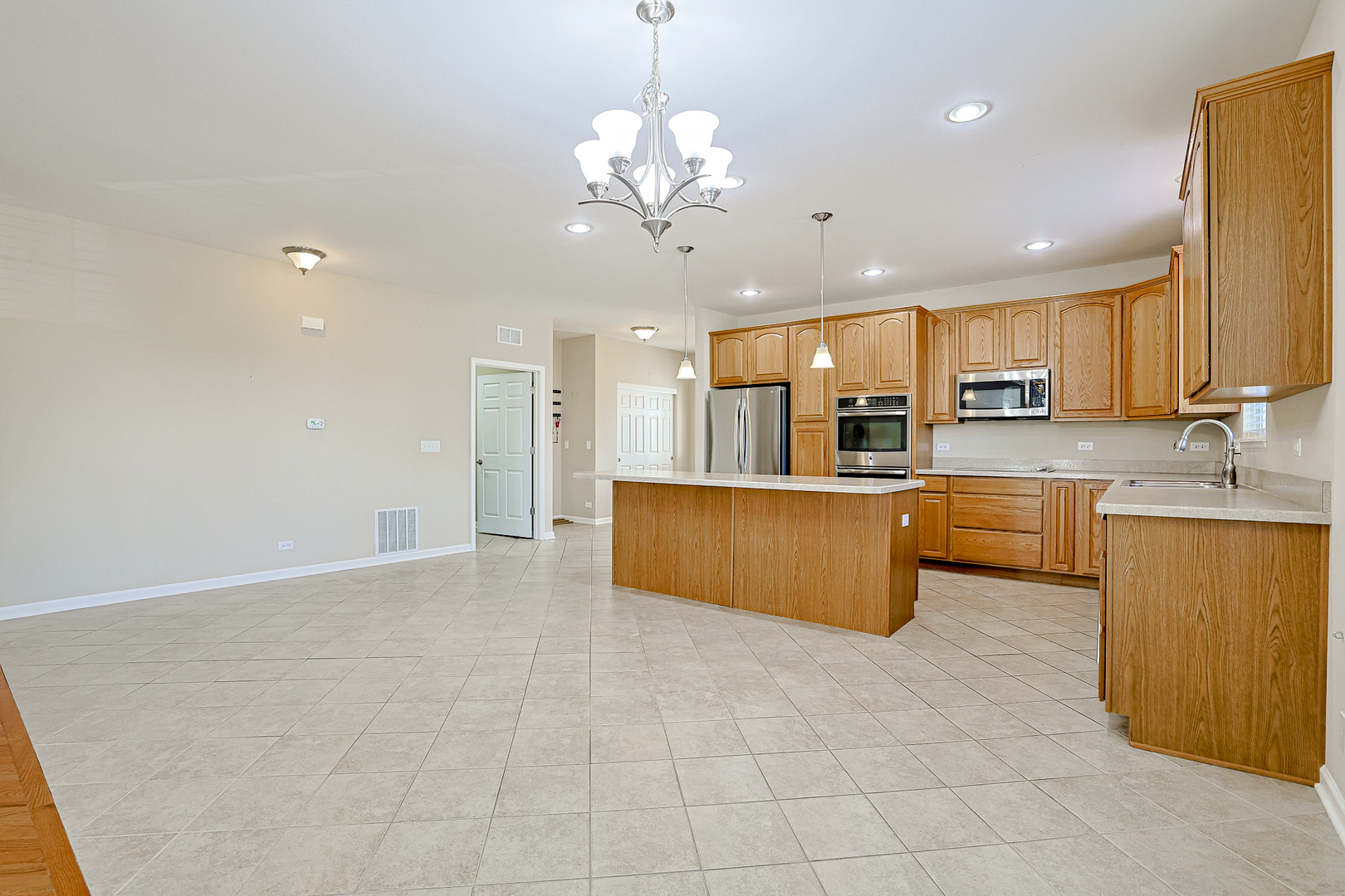 8800 Templeton Road Huntley, IL 60142 - Photo 8 of 31 a large kitchen with a chandelier a sink stainless steel appliances and cabinets