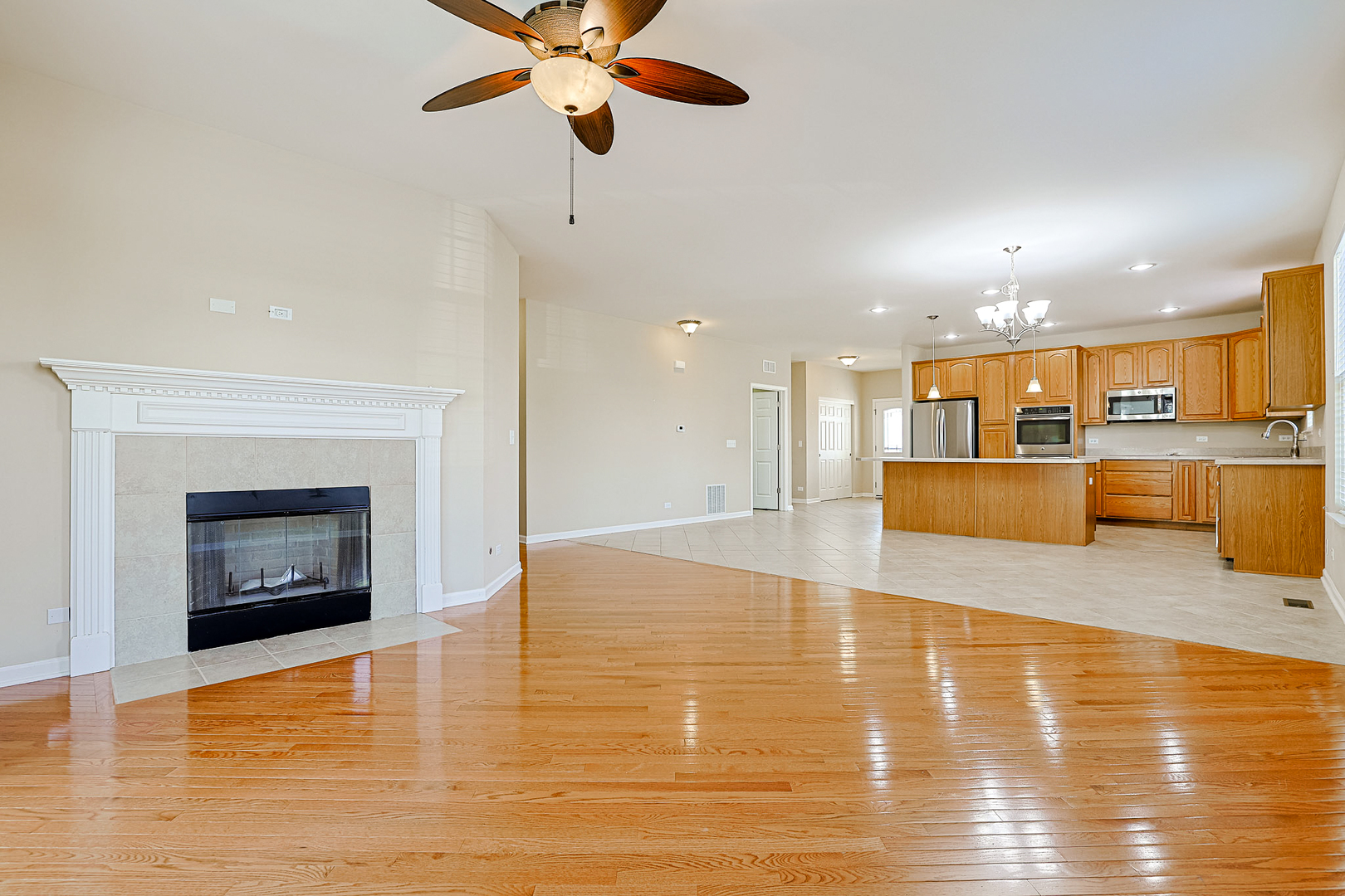 8800 Templeton Road Huntley, IL 60142 - Photo 10 of 31 a view of a kitchen with a kitchen island wooden floor appliances and a ceiling fan