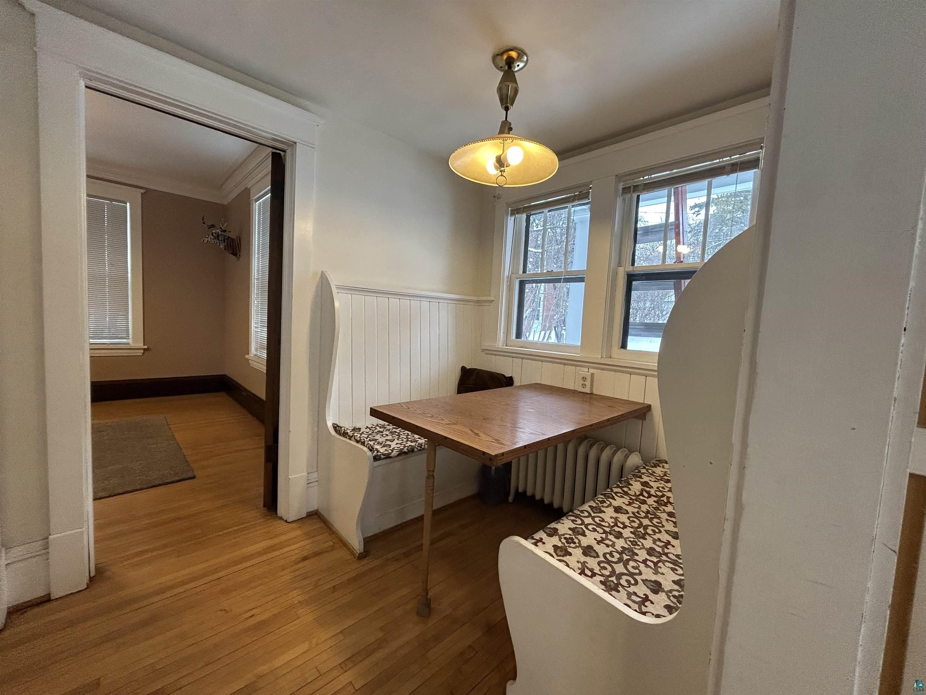 1723 East 4th Street Duluth, MN 55812 - Photo 14 of 47 Dining area featuring hardwood / wood-style flooring, radiator, ornamental molding, wainscoting, and breakfast area