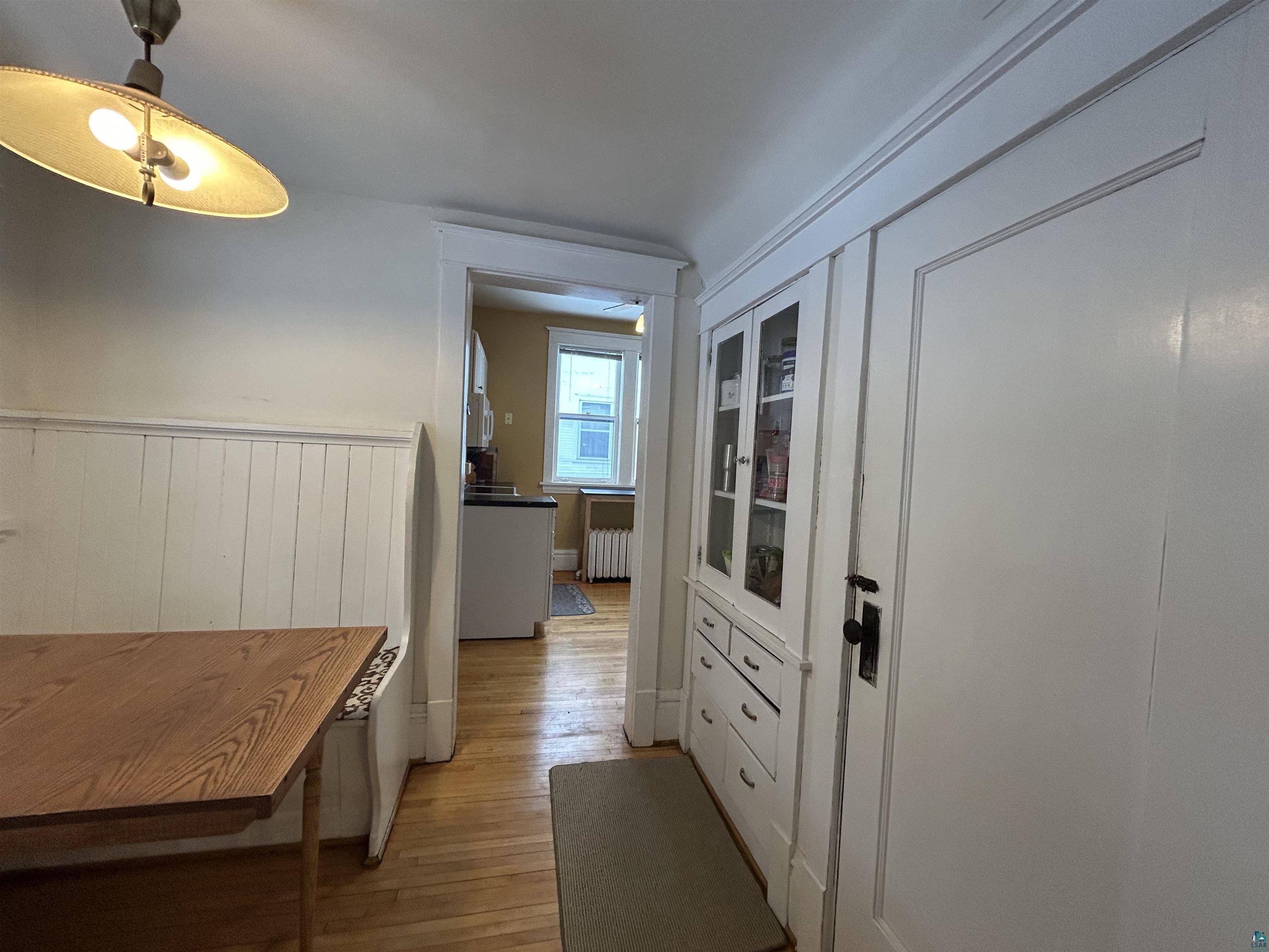 1723 East 4th Street Duluth, MN 55812 - Photo 15 of 47 featuring light wood-style floors, radiator, and a wainscoted wall