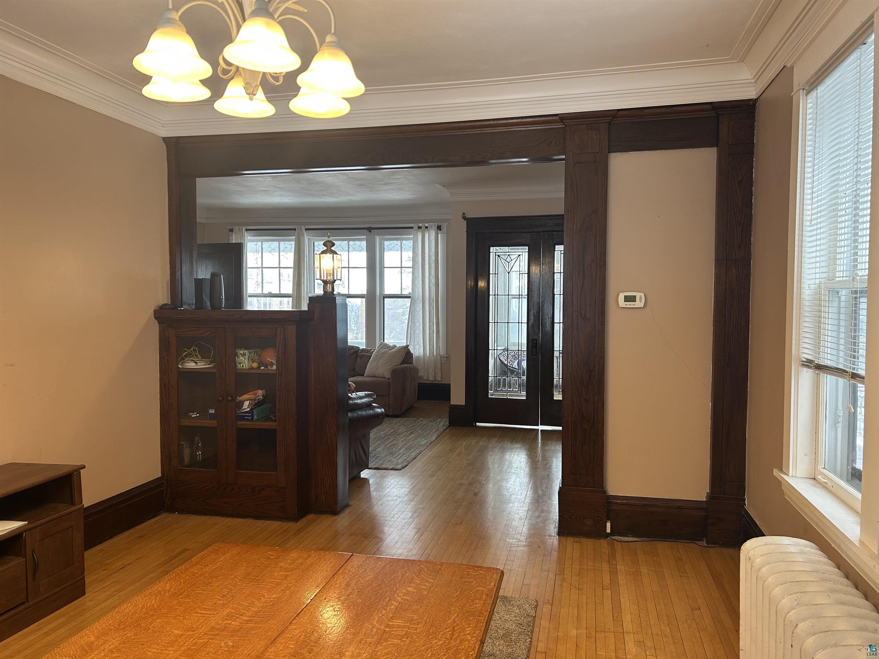 1723 East 4th Street Duluth, MN 55812 - Photo 32 of 47 Entryway featuring radiator, light wood-style flooring, ornamental molding, and hanging lights