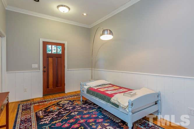 906 Runnymede Road Raleigh, NC 27607 - Photo 17 of 25 a bedroom with a bed and wooden floor