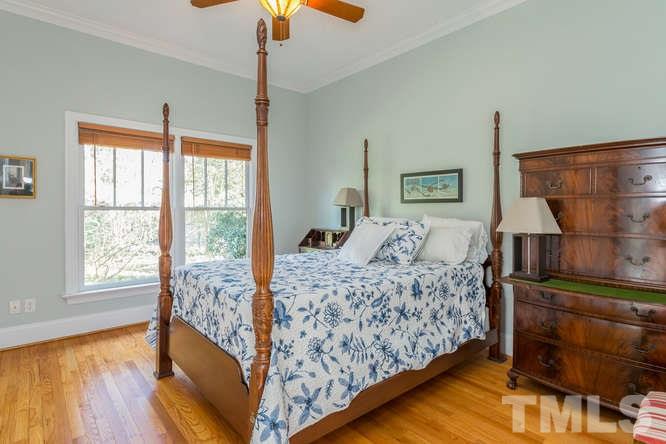906 Runnymede Road Raleigh, NC 27607 - Photo 20 of 25 a bedroom with a bed and wooden floor