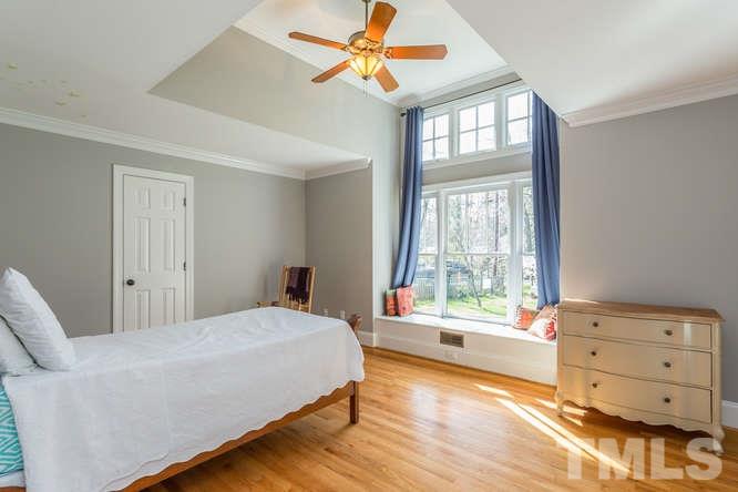 906 Runnymede Road Raleigh, NC 27607 - Photo 21 of 25 a bedroom with a bed and a dresser next to a window