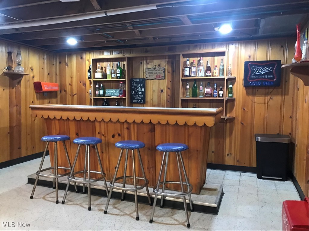 8330 Knauf Road Canfield, OH 44406 - Photo 24 of 34 Bar with wooden walls, a dry bar, and tile patterned floors