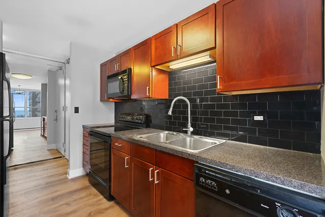 a kitchen with stainless steel appliances granite countertop a sink and wooden cabinets