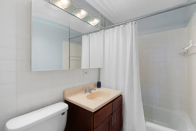 a bathroom with a sink a toilet and shower curtain