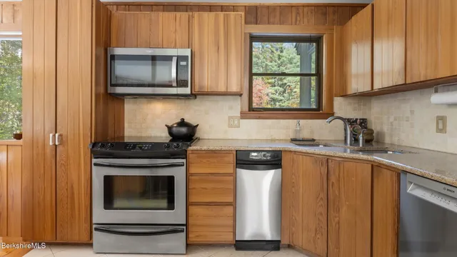 a kitchen with appliances a counter and cabinets