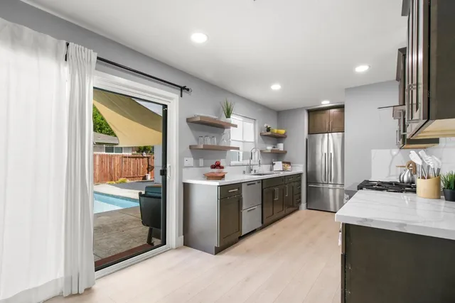 a kitchen with stainless steel appliances a sink and a refrigerator