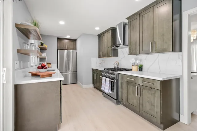 a kitchen with stainless steel appliances granite countertop a refrigerator and a sink