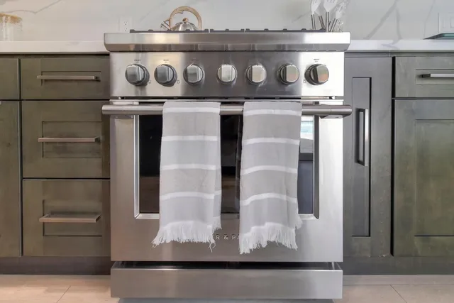 a kitchen with stainless steel appliances granite countertop a lot of cabinets and wooden floor