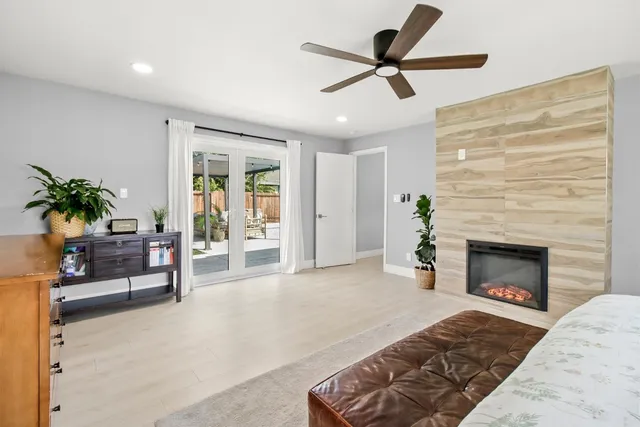 a dining room with chandelier fan and wooden floor
