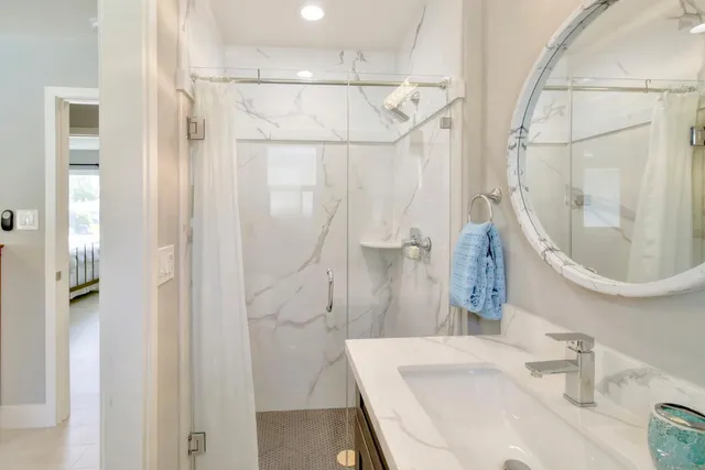 a view of a white house with a big yard plants and large trees