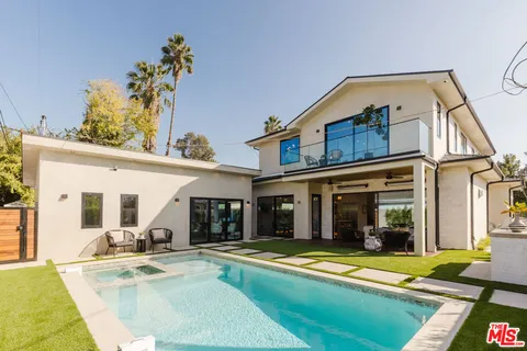 a view of a house with swimming pool and sitting area