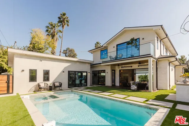 a view of a house with swimming pool and sitting area