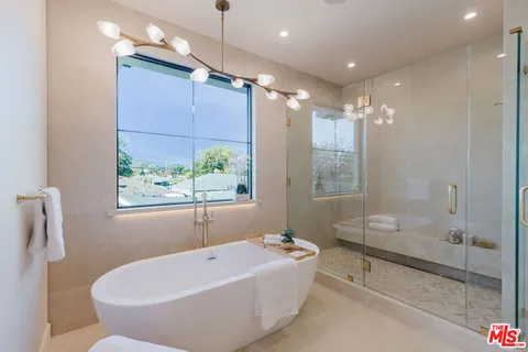 a bathroom with a tub a sink and a shower