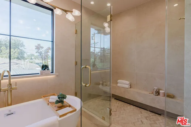 a bathroom with a tub a toilet and a shower