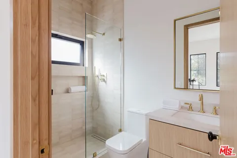 a bathroom with a toilet sink vanity and mirror