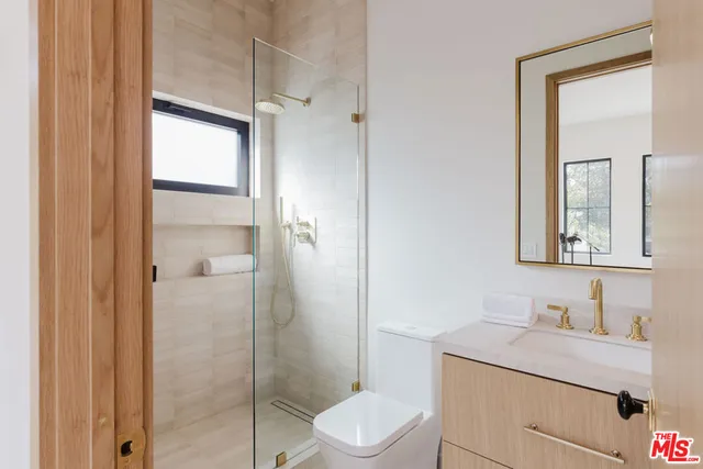 a bathroom with a toilet sink vanity and mirror