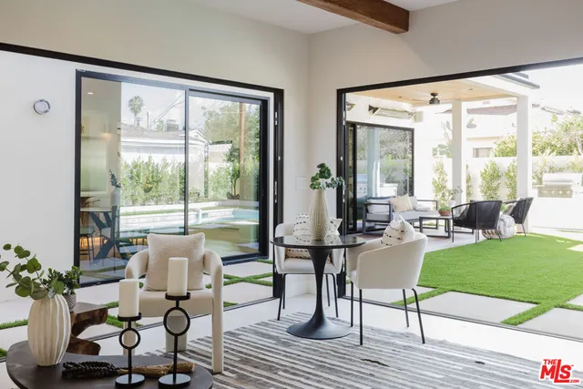a living room with furniture and a large window with wooden floor