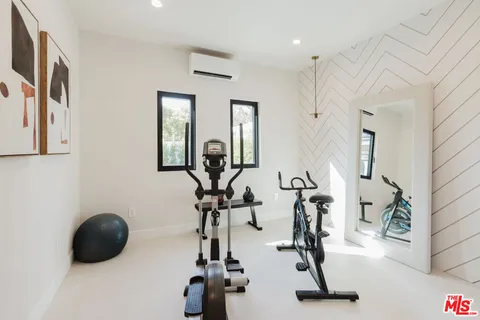 a room with gym equipment and large mirror