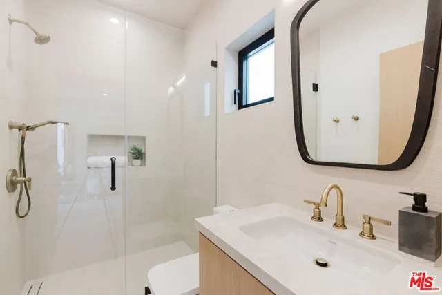 a bathroom with a sink vanity mirror and toilet