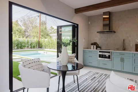 a kitchen with a table chairs and a window