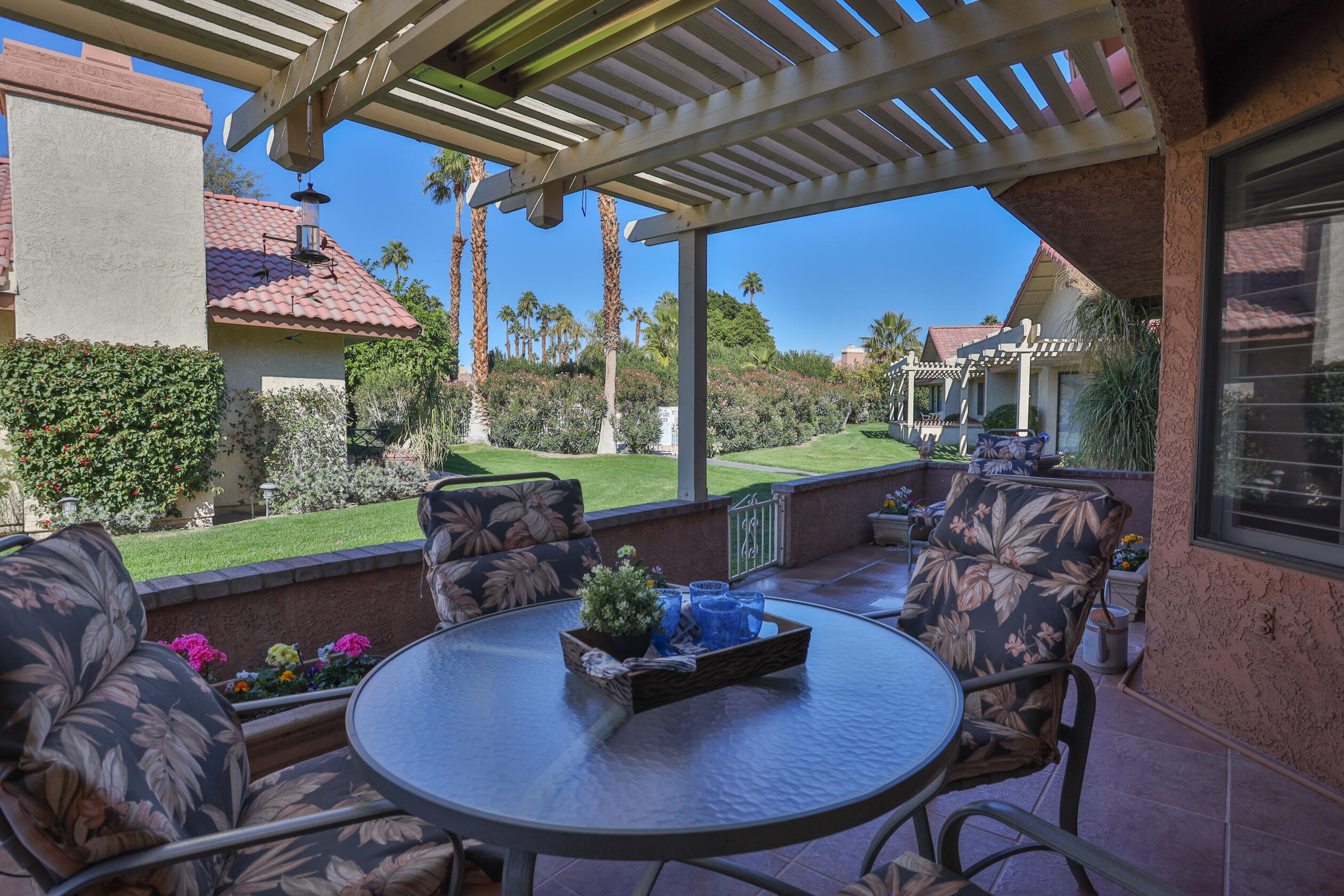 42895 Scirocco Road Palm Desert, CA 92211 - Photo 41 of 64 a view of a patio with a table chairs and a backyard