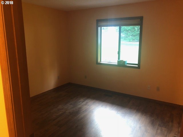 7635 Southeast Barbara Welch Road Portland, OR 97236 - Photo 12 of 26 an empty room with wooden floor and windows